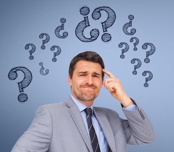 confused businessman standing with graphics over head